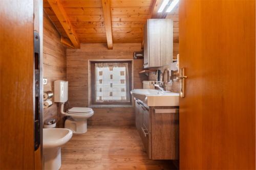 a bathroom with a sink and a toilet and a window at CROSINA HOLIDAY - Casa Al Ponte in Ledro
