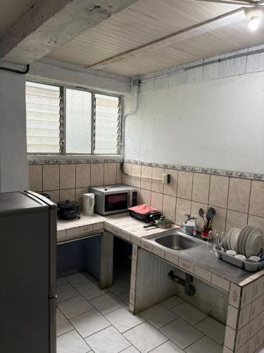a kitchen with a sink and a microwave at Villa Descanso in Colón