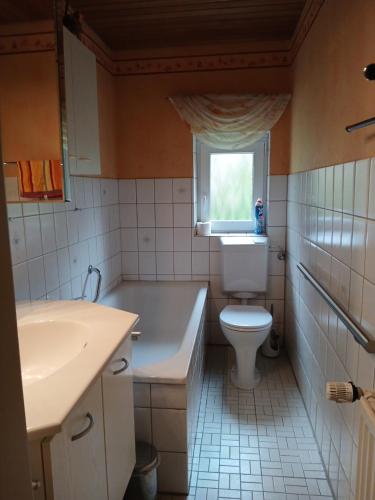 a bathroom with a tub and a toilet and a sink at Haus am Kirschbaum in Belum
