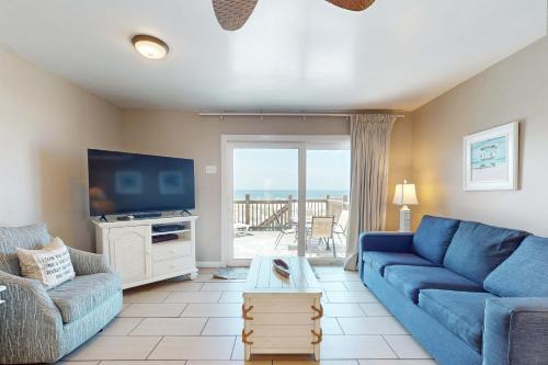 a living room with a blue couch and a tv at Sweet Alabama in Gulf Shores
