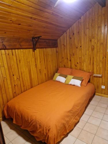 a bedroom with a bed in a wooden room at La Chênaie in Crespin