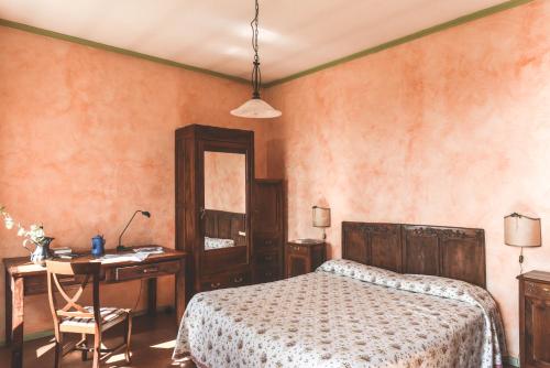 a bedroom with a bed and a desk and a table at Relax Cascina Lissona in Sessant