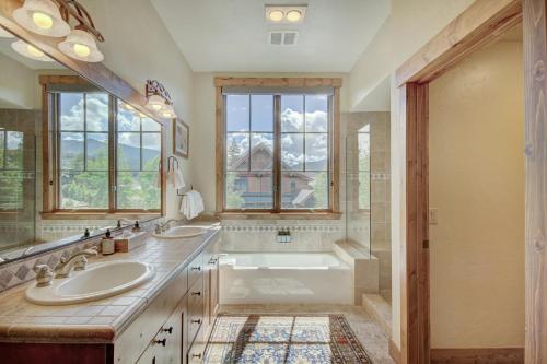 a bathroom with two sinks and a tub and a window at Mountain Thunder Lodge, A Vail Resorts Property in Breckenridge