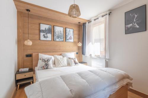 a bedroom with a large white bed and a window at L'Altima Megève in Megève