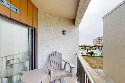 a white chair sitting on a balcony with a table at Gulfside Townhomes 23 in Gulf Shores