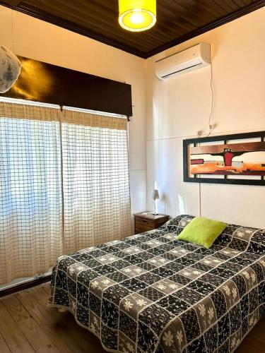 a bedroom with a bed with a black and white blanket at La Escondida de Tigre in Tigre