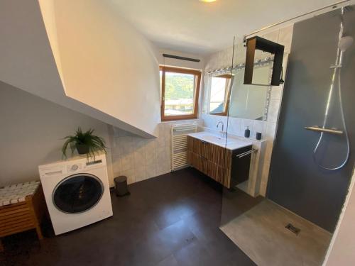 a bathroom with a washing machine and a sink at Fantastic apartment with unique panoramic views in Kuchl in Größing