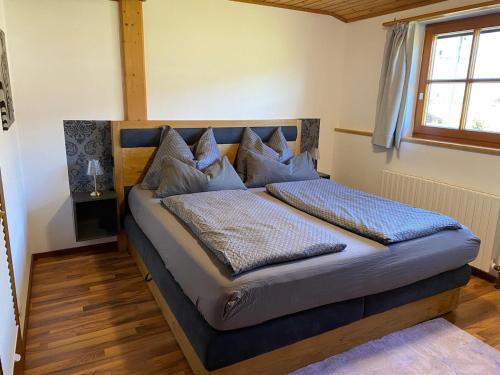 a bedroom with a bed with blue sheets and pillows at Fantastic apartment with unique panoramic views in Kuchl in Größing