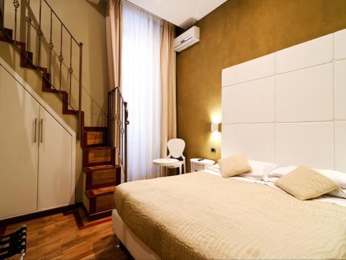 1 dormitorio con 1 cama grande y una escalera en Cenci Bed & Breakfast Fontana di Trevi, en Roma