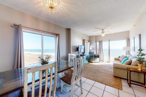 a living room with a dining table and a view of the ocean at Tidewater 601 in Orange Beach