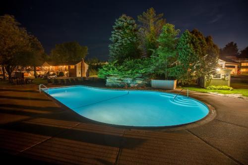 a large blue swimming pool in a yard at night at The Yankee, Trademark Collection by Wyndham in Lenox
