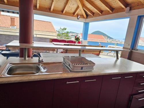 a kitchen with a sink and a table with a view at Guest House Banana in Dubrovnik