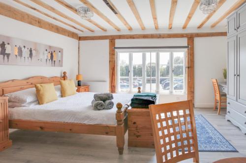 a bedroom with a wooden bed and a window at Maldon Executive Apartments in Maldon