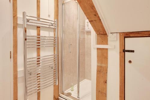 a glass shower in a bathroom with a window at Maldon Executive Apartments in Maldon