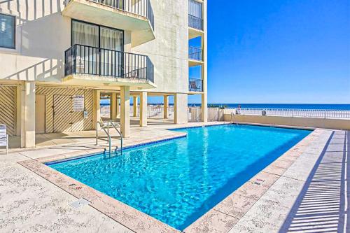 a swimming pool in front of a building with the ocean at The Whaler 7B in Gulf Shores