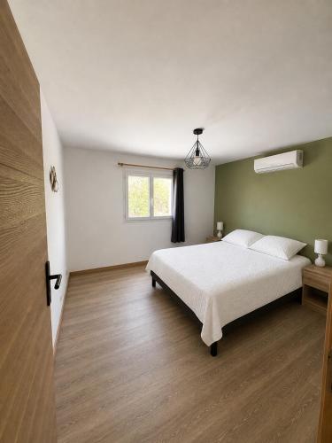 a bedroom with a white bed and a window at Villa Patja in Béziers