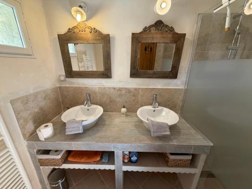 a bathroom with two sinks and two mirrors at Mas des Fleurs in Châteaurenard