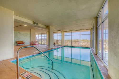 a swimming pool in a building with windows at Gulf front condo with great views shared pools & beach access in Orange Beach