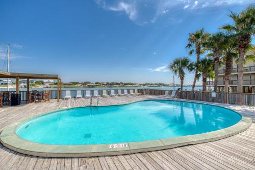 a swimming pool on a deck with palm trees at Gulf front condo with great views shared pools & beach access in Orange Beach