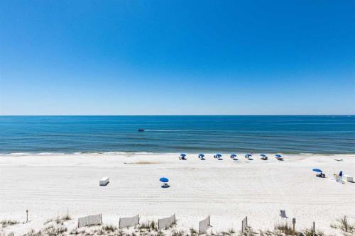 a beach with a row of chairs and the ocean at Beachfront Condo with Gorgeous Gulf View Balcony & Shared Pools in Orange Beach