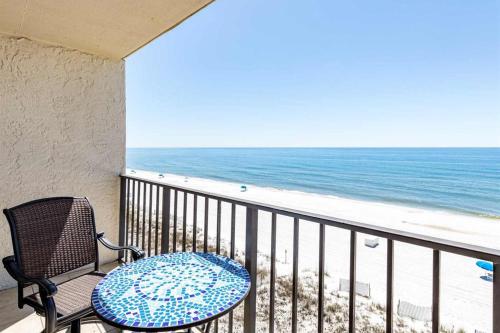a balcony with a table and a chair and the beach at Beachfront Condo with Gorgeous Gulf View Balcony & Shared Pools in Orange Beach