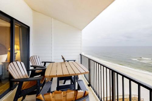 a balcony with a table and chairs and the ocean at Gulf-front corner condo with wraparound balcony pools beach access in Orange Beach