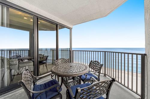 a balcony with a table and chairs and the ocean at Broadmoor 604 in Orange Beach