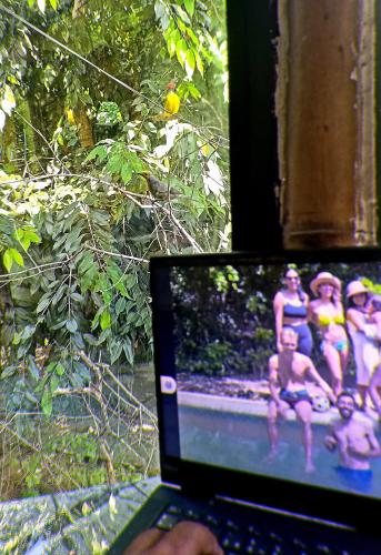 a person holding a laptop with a picture of a group of people at Bio Coliving Tayrona, Eco Retreat for You or Your group with Fast, Reliable WiFi & Power in Nature in Santa Marta