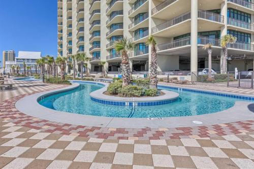 a swimming pool in front of a large building at Phoenix West 502 in Orange Beach