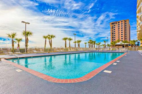 a swimming pool in a parking lot with palm trees at Regency Isle 805 in Orange Beach