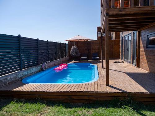 a swimming pool on a wooden deck next to a house at Villa Maris in Demre