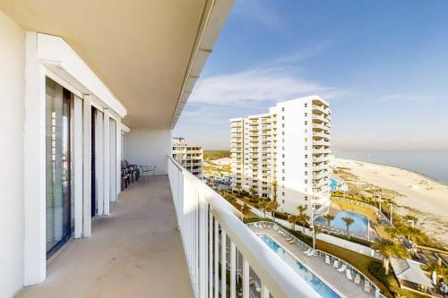 a balcony with a view of the beach and buildings at Fantastic condo with elevator WiFi & central AC - beachfront Location in Orange Beach