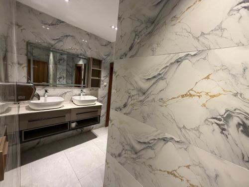 a bathroom with two sinks and a marble wall at de brit hotel in Benin City