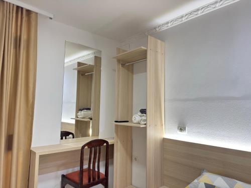 a bedroom with a desk and a chair and a mirror at Guest House Kasa Garden in Durrës