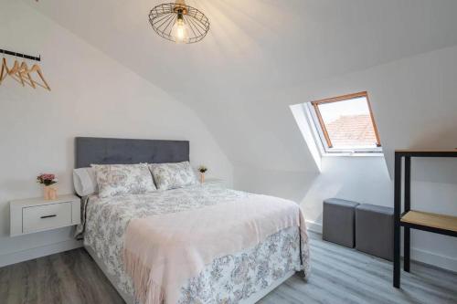 a white bedroom with a bed and a window at A Casita do Muelle in Cambados