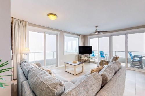 a living room with a large couch and a tv at Silver Beach 601 in Orange Beach