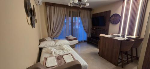 a small room with a bed and a table at Peralun Lux Apartments in Nea Peramos