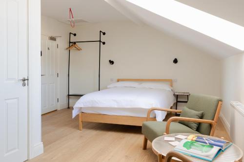 a bedroom with a bed and a chair and a table at Check In Belfast in Belfast