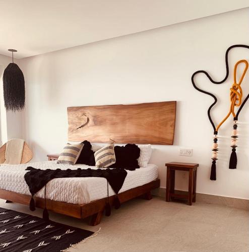 a bedroom with a bed with a wooden headboard at Bantay 5f in Bucerías