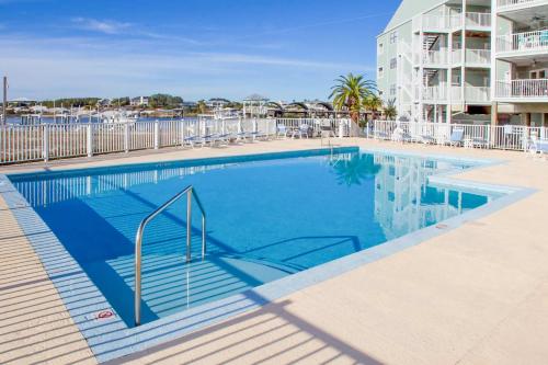 a swimming pool at a resort with chairs and a building at Jubilee Landing 302 in Orange Beach