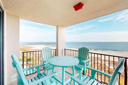 a table and chairs on a balcony with the beach at Phoenix East 702 in Orange Beach