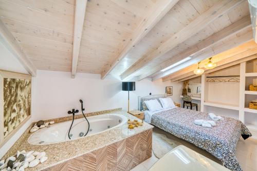 a bedroom with a bed and a tub in a room at Kalamoti Suites in Kalamoti