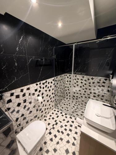 a bathroom with a toilet and a glass shower at Dorćol Center Suites in Belgrade