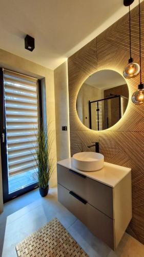 a bathroom with a sink and a mirror at Bosarosa Forest & Lake Villa z jacuzzi wanna SPA in Laski Małe