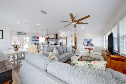 a living room with a blue couch and a ceiling fan at Mermaid Tales in Dauphin Island