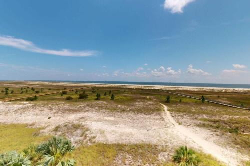 an aerial view of a desert with palm trees and the ocean at Beachfront condo with pool private balcony and laundry in Dauphin Island