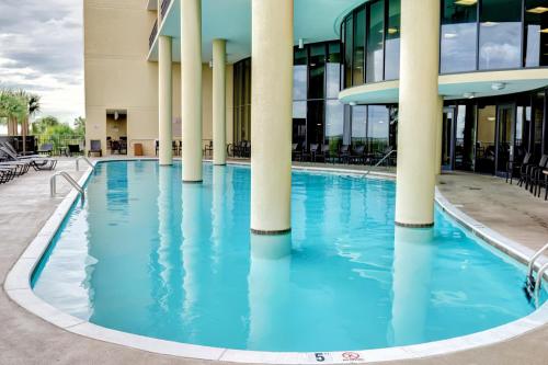a pool in front of a building with columns at Holiday Isle 618 in Dauphin Island