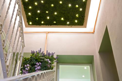 a skylight in a stairwell with a window with flowers at Navigliotel 19 - Rooms & Suites in Milan