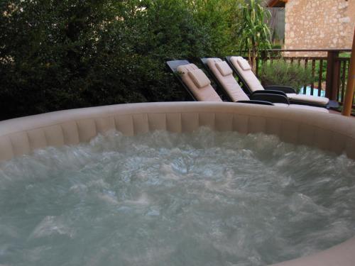 a jacuzzi tub with two chairs in a backyard at Hotel Aurora in Vallarsa