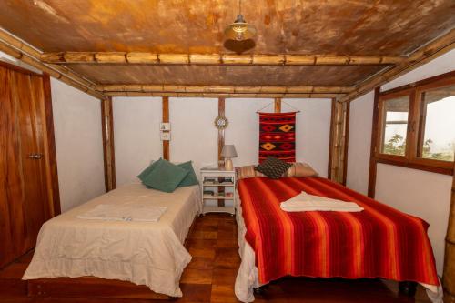 a bedroom with two beds in a room at Highland Bamboo Cabin, San Cristóbal Galápagos in San Cristóbal